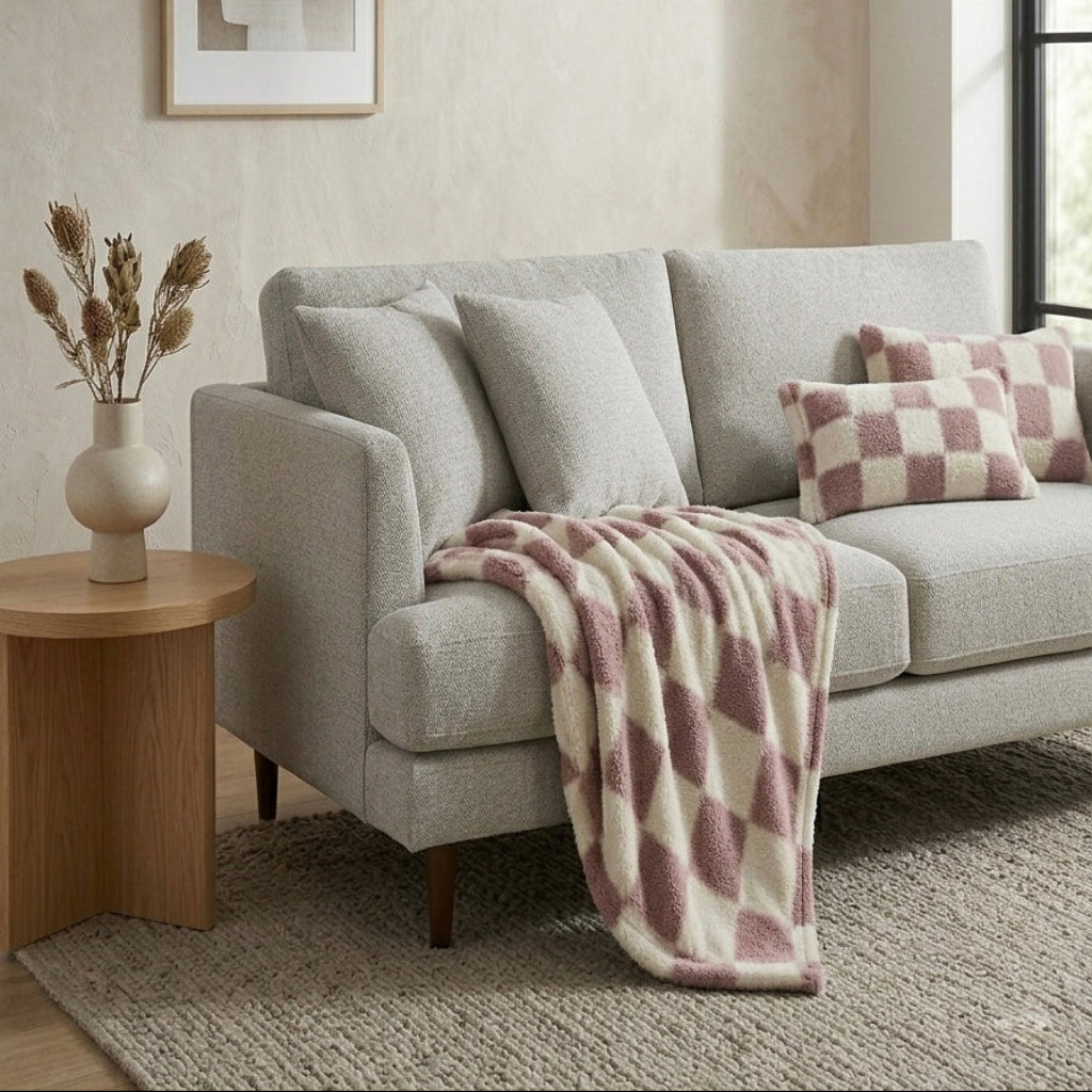 Pink checkerboard throw blanket draped over sofa modern living room Australia