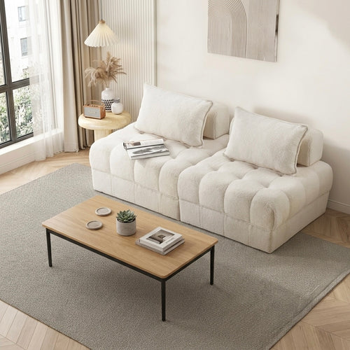 Modern living room with a white sofa, wooden coffee table, and decorative items.