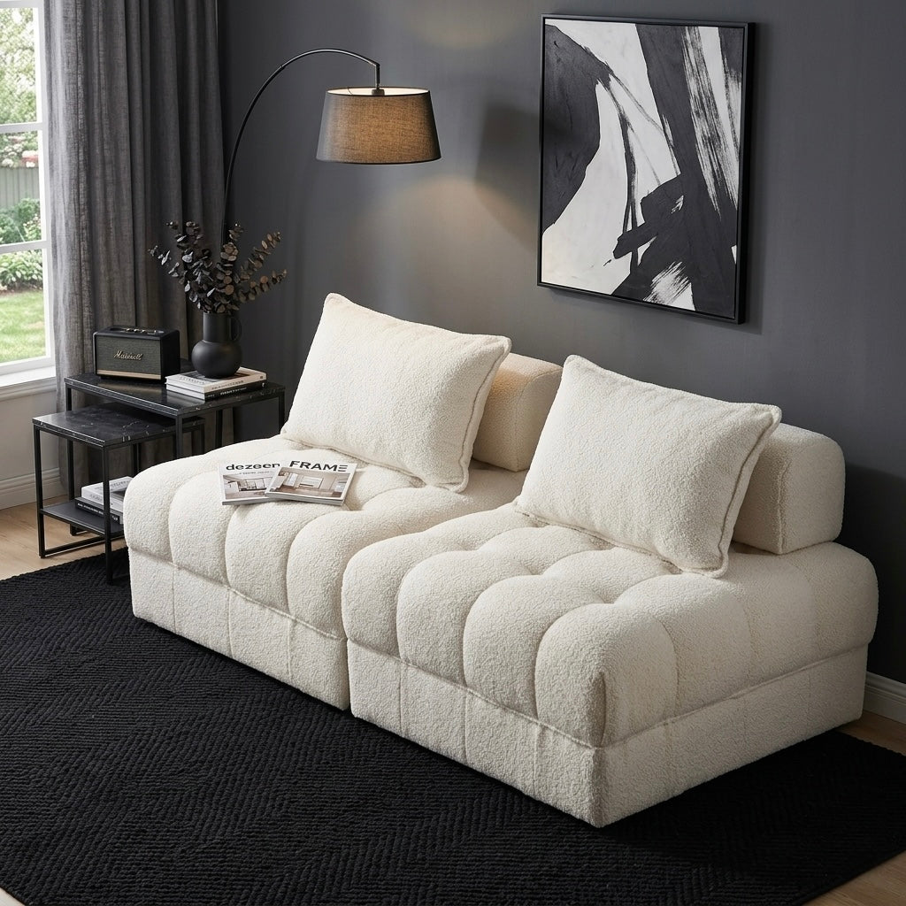 Beige sectional sofa in a living room with a dark gray wall, lamp, and abstract art.